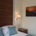 The Woodvale, Cowes guest room with single bed, bedside lamp and sunset wall art