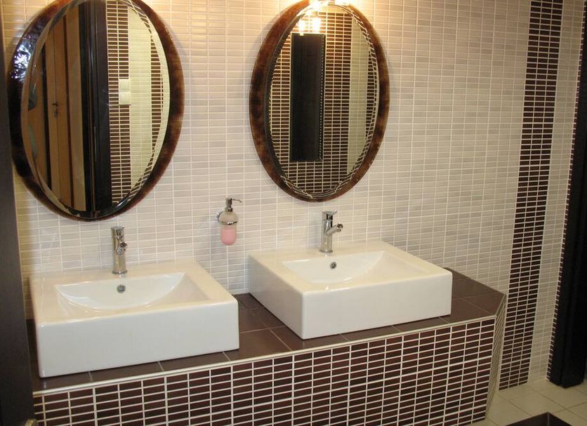 Hotel Prigipikon Suites and sofites bathroom with double sinks and oval mirrors in Loutra Ypatis