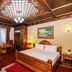 Brilant Antik Hotel in Tirana guest room with ornate wood ceiling, two beds, desk, and chandelier