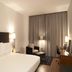 Palau de Bellavista Girona by URH guest room with bed, chair, desk and floor-to-ceiling curtains