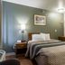 HomeTowne Studios by Red Roof Denver - Lakewood West guest room with queen bed and nightstands