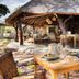 Kwafubesi Tented Safari Camp in Rooiberg: open-air dining deck with wooden tables under a thatched roof