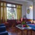 Hotel Tashi Delek in Gangtok: cozy lounge with blue sofa, coffee table and window view
