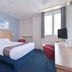 Travelodge Bedford Marston Moretaine guest room in Bedford with double bed, desk, chair and window