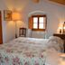 Agriturismo Montereggi in Fiesole bedroom with floral bedspread, arched window and warm lamp