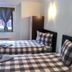 Flora Daisy Apartment in Borovets guest room with two plaid beds and a window with curtains