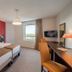 Appart'City Classic Genève - Gaillard guest room with twin beds, desk, wall TV and window view.