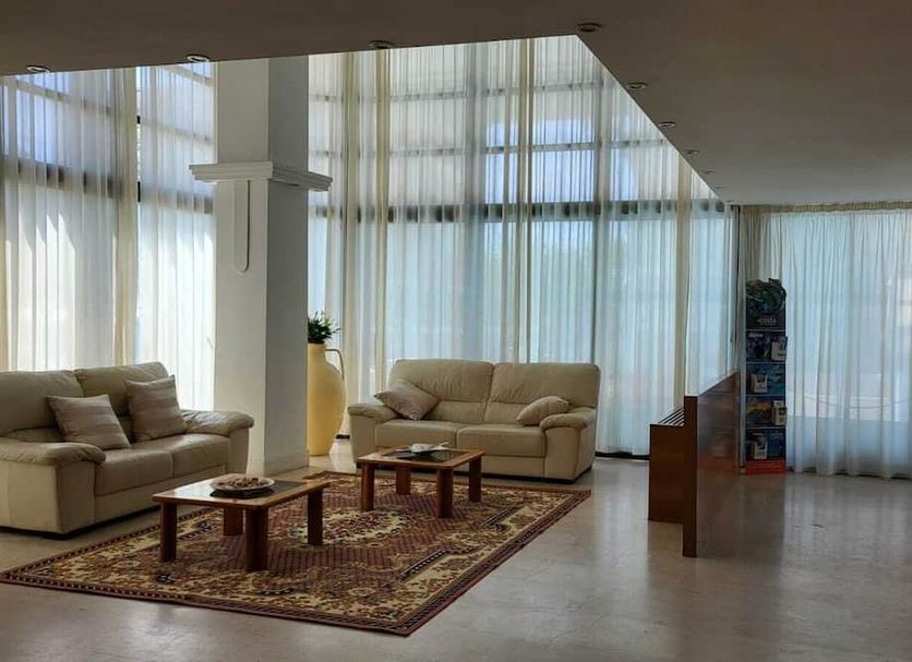 Grand Meeting Hotel Rimini lounge with sofas, coffee tables, patterned rug, and floor-to-ceiling windows