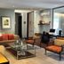 Hotel Los Españoles Plus in Santiago: modern lounge with sofas, glass coffee table and work desk