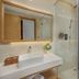 Tms Hotel Da Nang Beach bathroom with glass shower and bedroom view in Da Nang