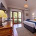Bronte Hotel Harare guest room with king bed, wood furniture, balcony doors and garden view