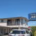 Tuki Tuki Motel in Waipukurau with sign, motel building, and parked car