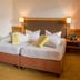 Vital Sporthotel Kristall in Finkenberg guest room with twin beds, bedside lamps and a vase of flowers