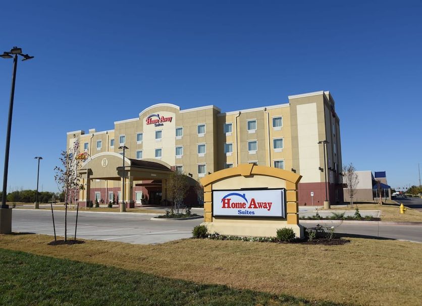 Home Away Kitchen Suites Enid exterior with entrance sign and parking lot