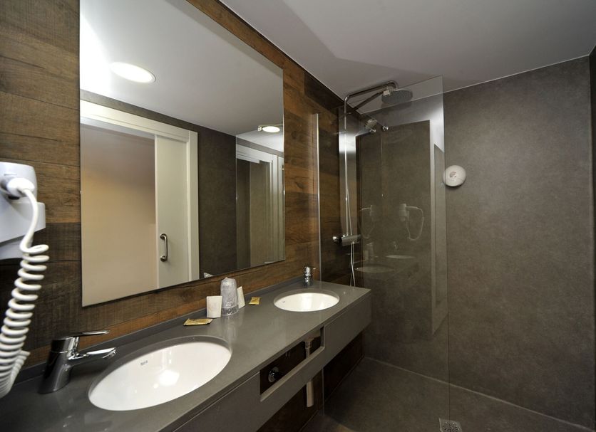 Hotel Vall D'Aneu bathroom with double sink vanity and glass shower in Esterri d'Àneu