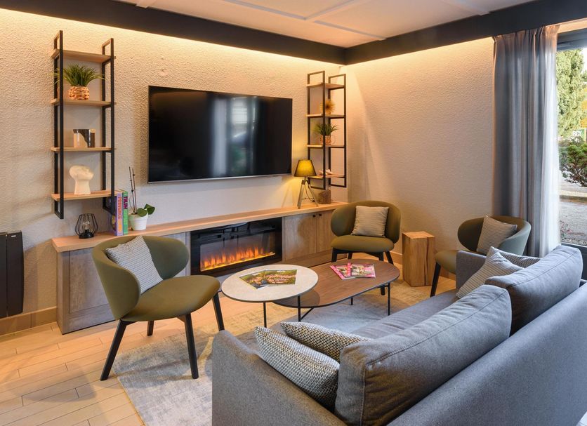 Campanile Nature - Cahors lounge with sofa, armchairs, fireplace and garden-view glass door in Cahors