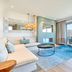 7Pines Resort Ibiza suite with ocean-view balcony, sofa seating and floor-to-ceiling windows in Sant Josep de sa Talaia