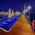 Ulusoy Kemer Holiday Club - Kids Concept in Göynük: nighttime wooden pier lined with blue sun loungers and umbrellas