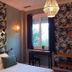 Les Lauriers in Saint-Tropez room with tropical wallpaper, bed, desk by window, and pendant light