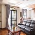 Lcs Hotel & Apartment in Phnom Penh room with leather sofa, coffee table and bed beside a balcony door.