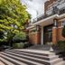 Hotel Orion in Ghent exterior with brick entrance, wide steps, and manicured shrubs