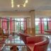Park Hotel Arbanassi lobby lounge with leather seating, glass tables and large windows overlooking greenery