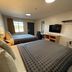 Americas Best Value Inn Ponca City guest room with two beds, desk, TV and window view