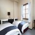 Hakuba Gondola Hotel in Hakuba guest room with two twin beds, desk, and windows with curtains.