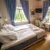 Karolineburg Manor House Hotel in Kajaani guest room with twin bed, vanity desk, and blue curtains
