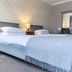 Woodcote Hotel in Ellesmere Port guest room with twin beds, bedside lamps, and patterned wallpaper