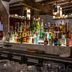 Petit Hôtel Confidentiel in Chambéry bar with many liquor bottles displayed on a marble counter