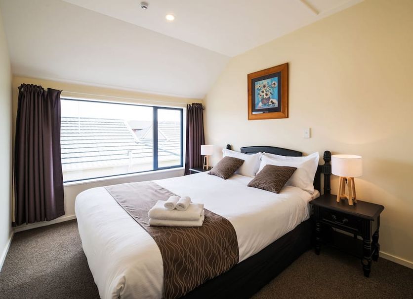 123 Motel Christchurch guest room with king bed, bedside lamps, and large window
