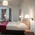 Kardinal Schulte Haus in Bergisch Gladbach hotel room with double bed, desk, tall windows and lamps
