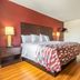 Red Roof Inn Phoenix-Midtown guest room with king bed, desk, and wood floors in Phoenix