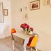Apartments Antonio in Cavtat room with open window, small dining table, and bright orange chairs