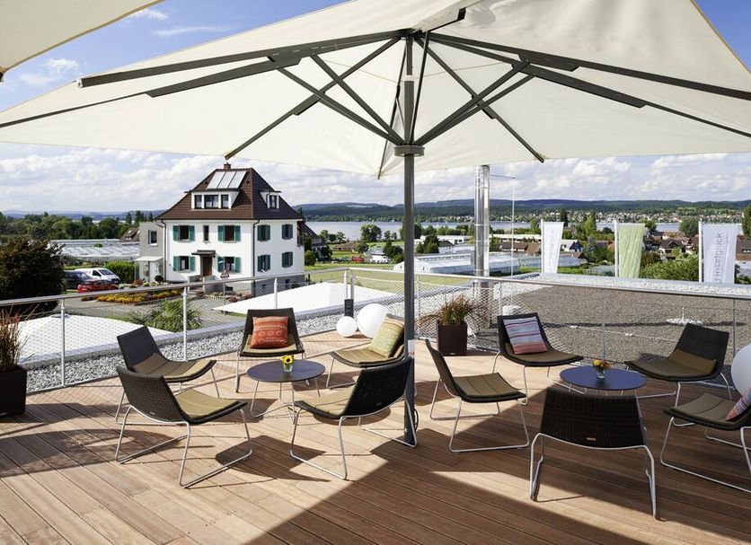 Hotel mein inselglück terrace with umbrella seating and lake view in Reichenau