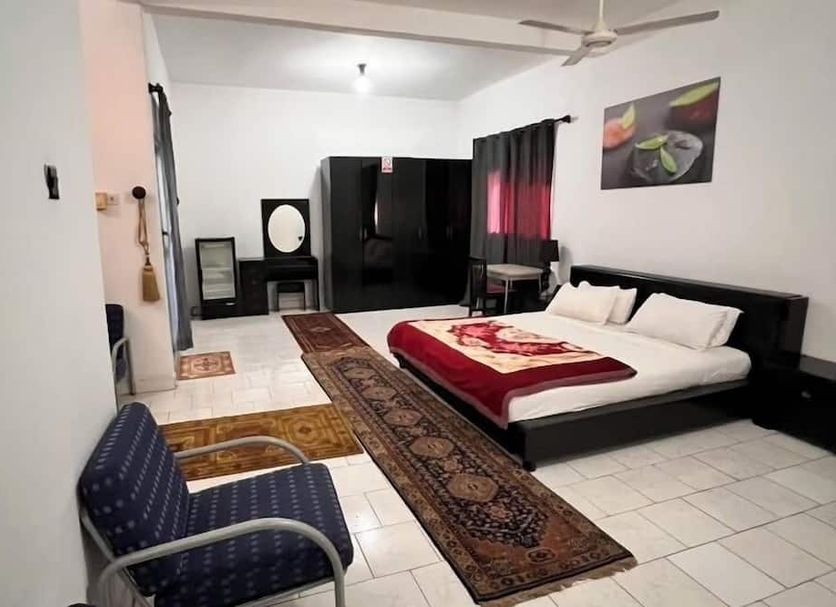 Woodpecker Resort Hotel in Serrekunda guest room with bed, wardrobe, seating area and ceiling fan