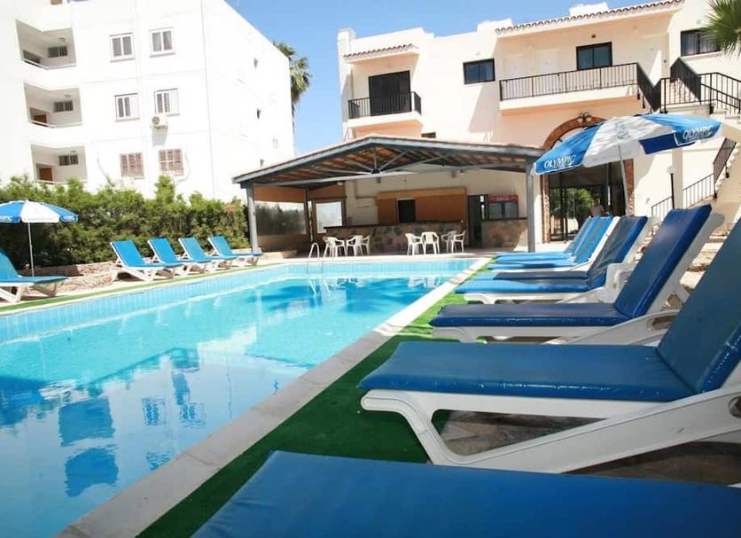 New York Plaza Hotel Apartments in Paphos with outdoor pool and blue sun loungers