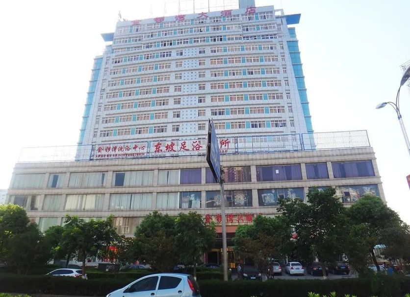 Jinluowan Hotel in Ji'an, a tall high-rise hotel with trees and cars in front