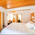 Mein Haus Bed & Breakfast in Avon, bright bedroom with wood ceiling, king bed and armchair