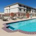 Pool area at Fairfield Inn & Suites by Marriott Odessa with lounge chairs and hotel building