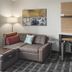 TownePlace Suites by Marriott Louisville Northeast room with sofa, desk, lamp and swivel chair