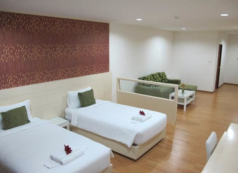 Baan Klang Hua Hin room with two twin beds, seating area, and wood flooring in Hua Hin