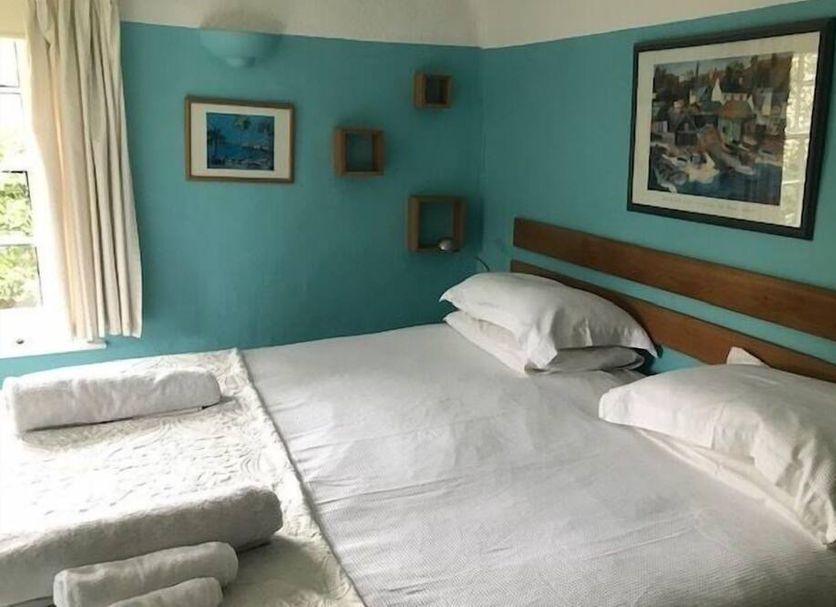 The White House in Bishop's Stortford guest room with a bed, teal walls, framed art and window