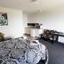 Lottin Point Motel in Hicks Bay guest room with patterned bed, kitchenette, desk and artwork