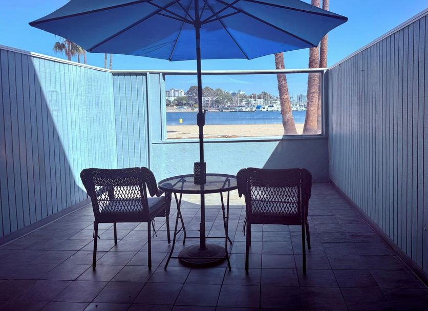 Foghorn Harbor Inn in Marina del Rey patio with table, chairs, and umbrella overlooking the harbor