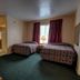 Ocean Beach Hotel in Miami Beach guest room with two beds, table, lamp, and window with curtains