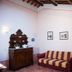Agriturismo Villa La Morina in Cortona: rustic lounge with striped sofa, fireplace, and wooden cabinet