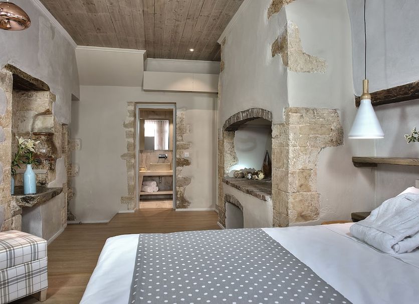 Elia Zampeliou Hotel, Chania: rustic hotel room with stone walls, exposed beams and a bed