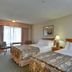 Vagabond Inn Ventura room with two beds, bedside lamp, and window seating in Ventura